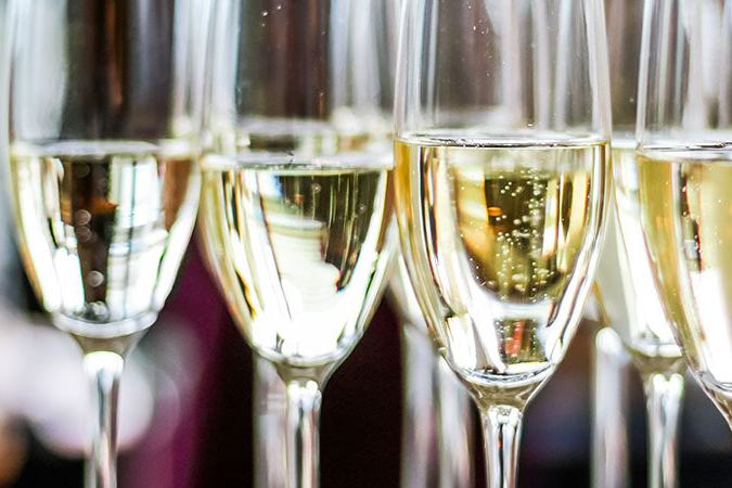 Mehrere mit Sekt gefüllte Sektgläser auf einem Tablett