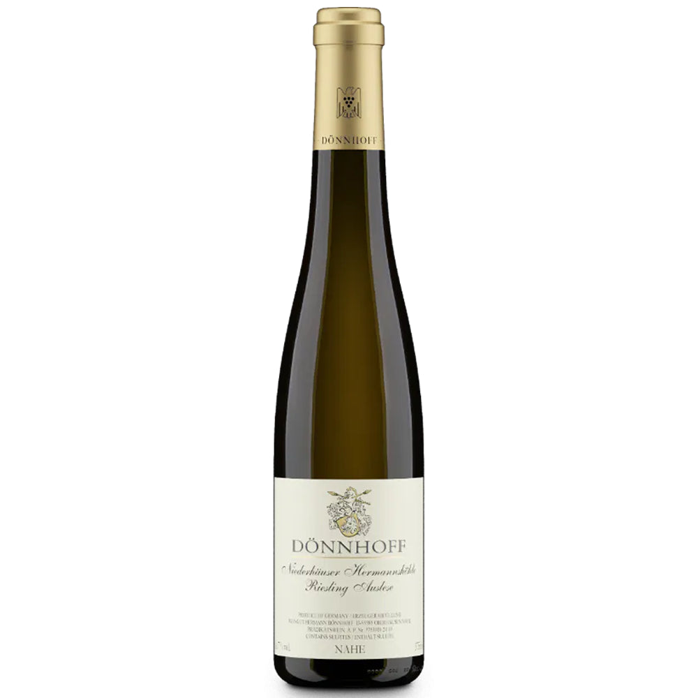 Eine hohe, elegante Flasche des Weinguts Dönnhoff – Riesling Auslese „Goldkapsel“ Niederhäuser Hermannshöhle 2010 – mit goldener Kapsel und cremefarbenem Etikett steht vor einem weißen Hintergrund und unterstreicht damit das Ansehen des renommierten Weinbergs Niederhäuser Hermannshöhle und seiner unverwechselbaren Bezeichnung „Goldkapsel“.