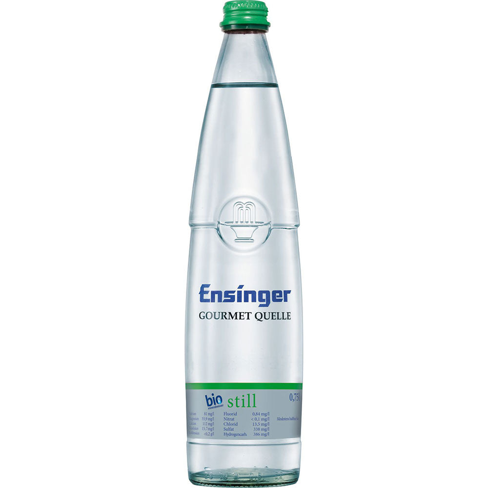 Eine Klarglasflasche Ensinger Gourmet BIO Stilles Mineralwasser (12x0,75L Mehrweg) mit grünem Verschluss und blauem Etikett.
