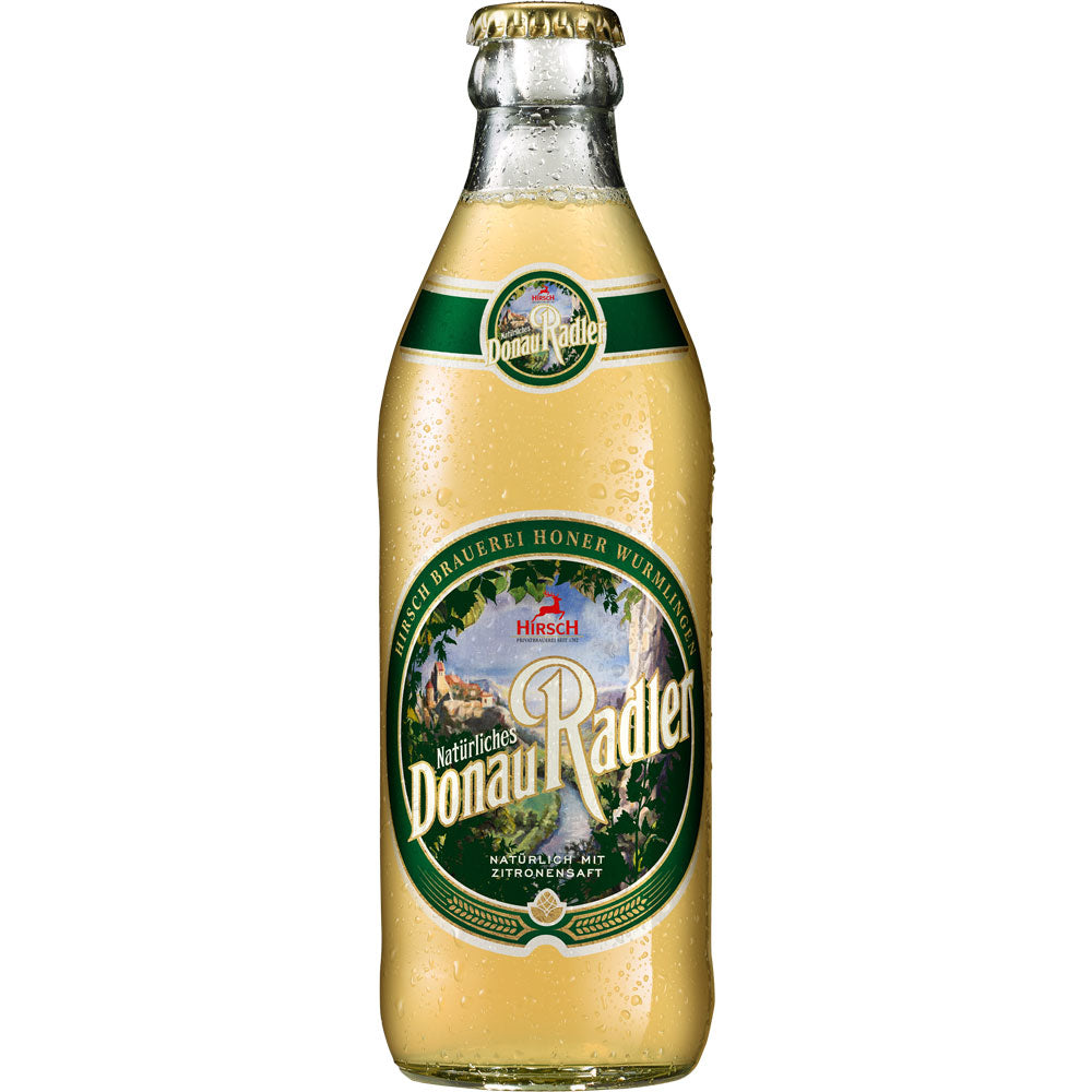 Eine Glasflasche Hirsch Natürliches Donau Radler der Hirsch Brauerei, ein natürlich gebrautes Radler-Bier mit Schwitzwasser und einem leuchtend grün-gelben Etikett, erhältlich in 20x 0,33L (Mehrweg).