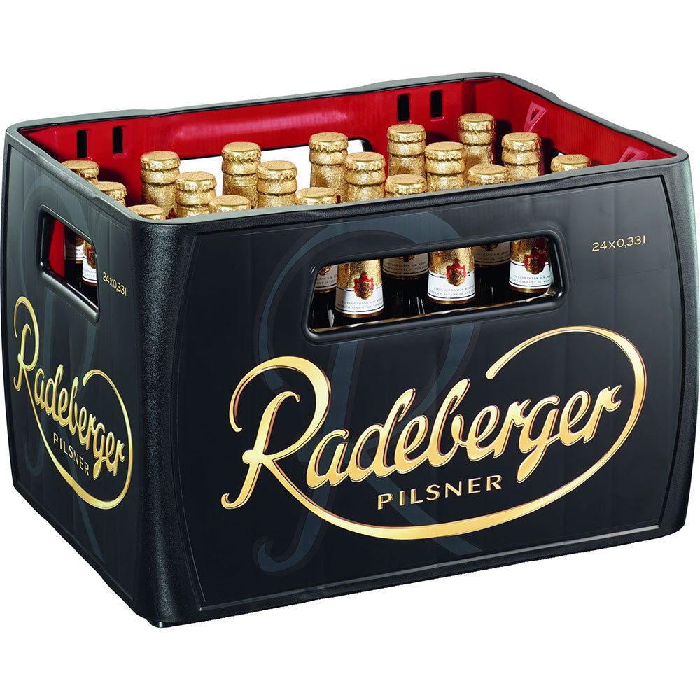 Eine schwarze Kiste mit 24 Flaschen Radeberger Pilsener 0,33L (Mehrweg) von Radeberger Pilsner, jeweils mit goldenen Etiketten und Verschlüssen.