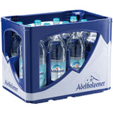 Eine blau-weiße Kiste der Adelholzener Alpenquelle Mineralwasser Naturell (MEHRWEG), die zwölf 0,75L Flaschen natriumarmes, natürliches Mineralwasser enthält.