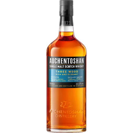 Auchentoshan Three Wood Single Malt Scotch Whisky 43% (0.7L) von Auchentoshan, mit schwarzem Verschluss und reichem orange-braunem Alkohol im Inneren.