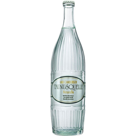 Aufrecht steht eine Klarglasflasche Taunusquelle Bad Camberger Taunusquelle Naturelle 0,75L (MEHRWEG) mit weiß-goldenem Etikett - erfrischendes stilles Mineralwasser aus einer Premium-Quelle.