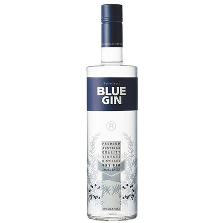 Eine klare Flasche Reisetbauer Blue Premium Gin 43% 0,7 Liter von Reisetbauer, mit einem blauen Etikett und silbernen botanischen Illustrationen auf der unteren Hälfte.