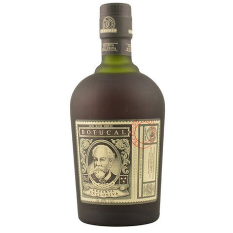 Eine dunkle Glasflasche Botucal Rum Reserva Exclusiva 12 Jahre 40% (0,7L), ein venezolanischer Premium-Rum, mit einem beigen Etikett, auf dem ein bärtiger Mann abgebildet ist.