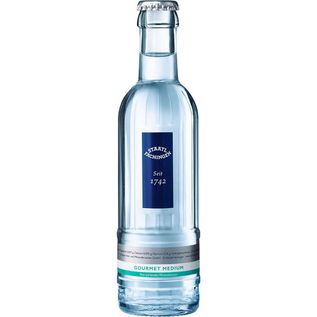 Eine Klarglasflasche von Staatl. Fachingen Gourmet Medium 24x0,25L (Mehrweg), mit blauem Etikett, bekannt für seinen hohen Hydrogencarbonatgehalt.