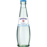Eine Klarglasflasche Gerolsteiner Gourmet Naturell 0,25L (Mehrweg), stilles Mineralwasser ohne Kohlensäure, mit blauem Verschluss und weißem Etikett. Packung mit 24 Stück. Marke: Gerolsteiner.