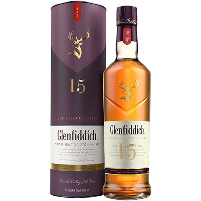 Eine Flasche Glenfiddich 15 Jahre Solera Reserve Single Malt Scotch Whisky 40% 0,7 Liter steht neben der stilvollen violett-goldenen Verpackungsröhre.