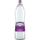 Eine 0,75-Liter-Glasflasche Griesbacher First Class Mineralwasser Still mit violettem Etikett und Verschluss, aus dem Schwarzwald stammend und reich an Hydrogencarbonat. Erhältlich in einem 12er-Pack (MEHRWEG).