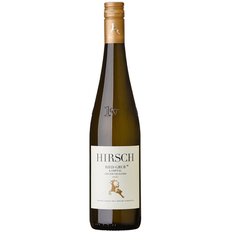 Eine Flasche „Weingut Hirsch Grüner Veltliner Ried Grub 1ÖTW Kamptal DAC 2021“ mit einem beigen Etikett und einem goldenen Hirsch-Logo unterstreicht den eleganten Charakter des Kamptaler Grünen Veltliners.