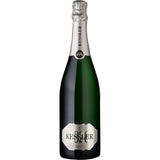 Eine 0,75-Liter-Flasche KESSLER Sekt Kessler Brut, mit silberner Folie und Etikett auf weißem Grund, hergestellt in traditioneller Flaschengärung.