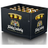 Eine schwarze Kiste mit der Aufschrift "König Ludwig" enthält 20 Flaschen (je 0,5 l) König Ludwig Weißbier Kristall mit goldenen Verschlüssen und gelben Etiketten.