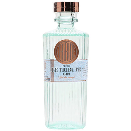 Eine klare, gerippte Glasflasche von Le Tribute Dry Gin 43% 0,7 Liter von Le Tribute, mit einem kupfernen Verschluss und einem hellblauen mit kupferfarbenem Etikett.