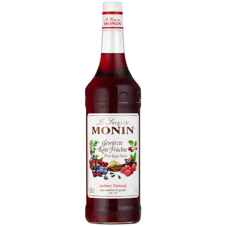Eine Flasche Monin Gewürzte Rote Früchte Sirup 1 Liter - ein alkoholfreier Sirup von Monin mit Beerenmotiven auf dem Etikett, ideal für fruchtige Drinks und Desserts.