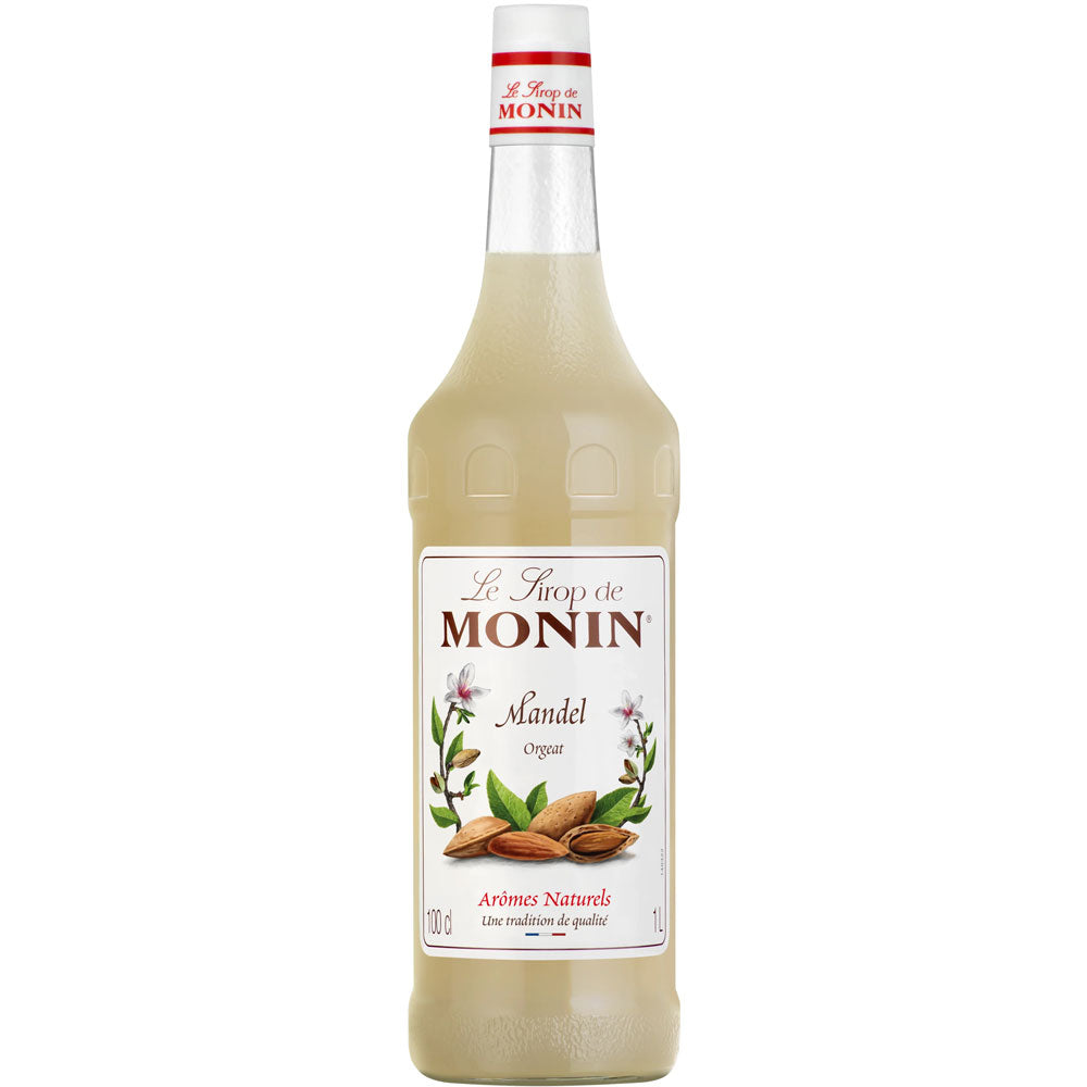 Eine 1-Liter-Flasche Monin Mandel Sirup von Monin mit einem weißen Etikett, auf dem Mandeln und Mandelblüten abgebildet sind.