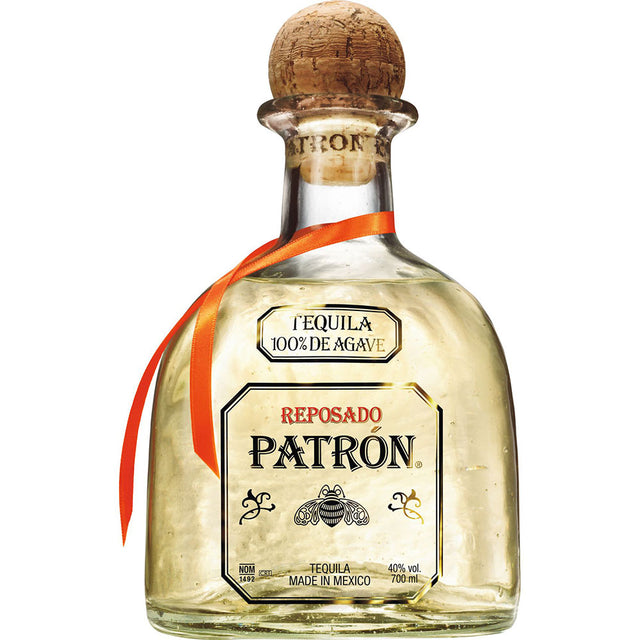 Eine 0,7-Liter-Flasche Patrón Tequila Reposado 100% Agave (40%) von Patrón Tequila, mit Korkverschluss und orangefarbenem Band um den Hals.