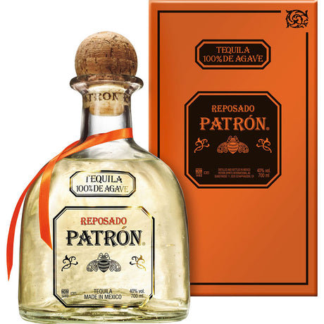 Eine Flasche Patrón Tequila Reposado 100% Agave 40% 0,7 Liter von Patrón Tequila, mit einem Korkverschluss und einer orangefarbenen Schachtel daneben.