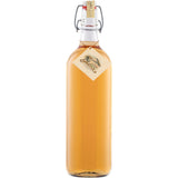 Klarglasflasche mit bernsteinfarbener Flüssigkeit, verschlossen mit Bügelverschluss und dekorativem Anhänger - ideal zur Präsentation von Prinz Alte Wald-Himbeere 41% 1 Liter der Feinbrennerei Thomas Prinz, einem hochwertigen Himbeerbrand.