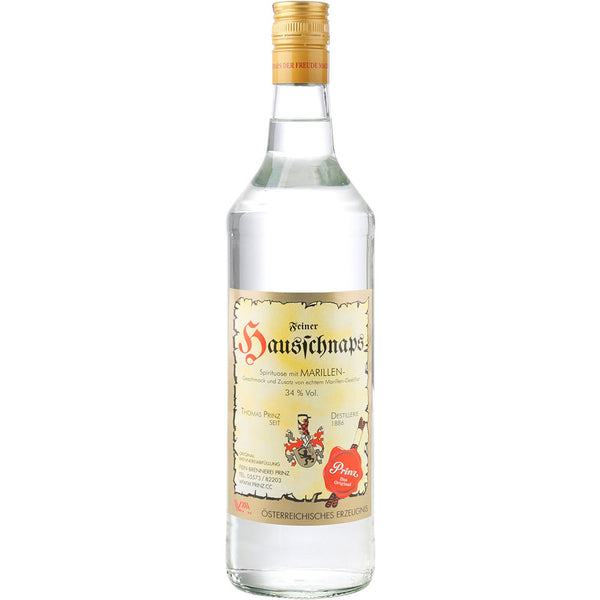 Eine 1L Flasche Feinbrennerei Thomas Prinz Hausschnaps Marille 34% mit cremefarbenem Etikett und goldenem Verschluss steht auf weißem Grund und hebt diesen klassischen österreichischen Marillenschnaps hervor.