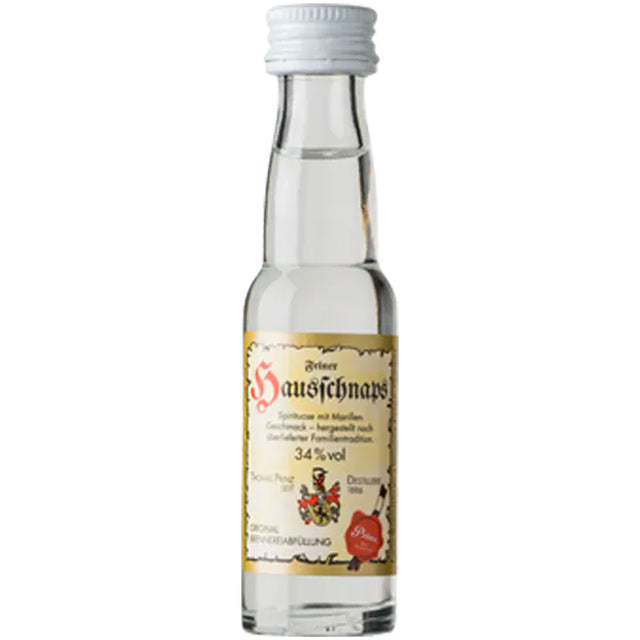 Eine kleine Klarglasflasche mit der Aufschrift "Prinz Hausschnaps Marille 34% 0,02 Liter" der Feinbrennerei Thomas Prinz, gefüllt mit klarem Schnaps und verschlossen mit einem weißen Deckel.