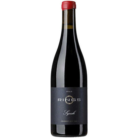 Eine dunkle Weinflasche mit rotem Verschluss und einem schwarzen Etikett mit der Aufschrift „Weingut Rings Syrah trocken 2020“, auf dem ein eleganter deutscher Rotwein aus Freinsheim präsentiert wird.