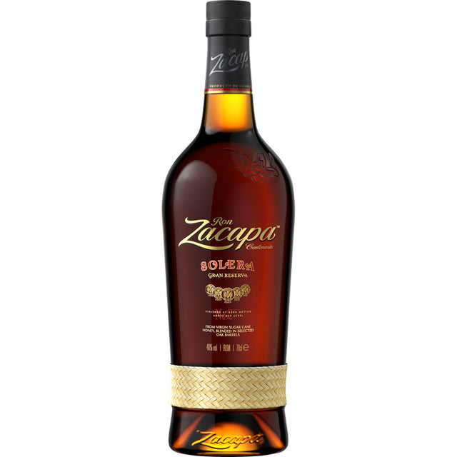 Eine Flasche Ron Zacapa Rum Solera Gran Reserva 40% (0,7L), ein bekannter guatemaltekischer Rum von Ron Zacapa, mit goldenem Etikett und gewebtem Band um den Boden.