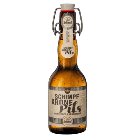 Eine Braunglasflasche Schimpf Krone Pils Bügel 0,33L (MEHRWEG) mit Bügelverschluss und Kondenstropfen unterstreicht die Brautradition seit 1430 der Marke Schimpf.