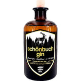 Eine braune 0,5-Liter-Flasche Schönbuch Premium Dry Gin (47%) von Schönbuch Gin, mit einem schwarzen Etikett, das die Silhouette eines Hirsches und eines Waldes zeigt und diesen handgefertigten Dry Gin aus Baden-Württemberg hervorhebt.