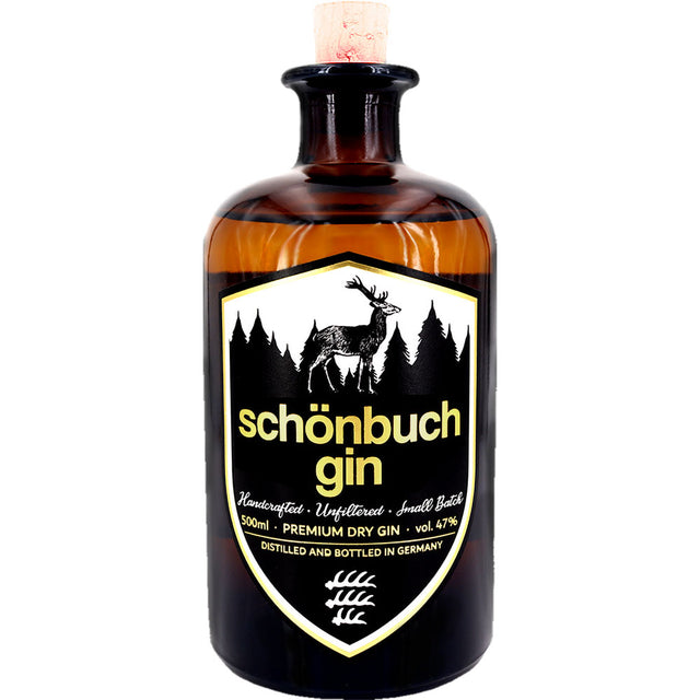 Eine braune 0,5-Liter-Flasche Schönbuch Premium Dry Gin (47%) von Schönbuch Gin, mit einem schwarzen Etikett, das die Silhouette eines Hirsches und eines Waldes zeigt und diesen handgefertigten Dry Gin aus Baden-Württemberg hervorhebt.