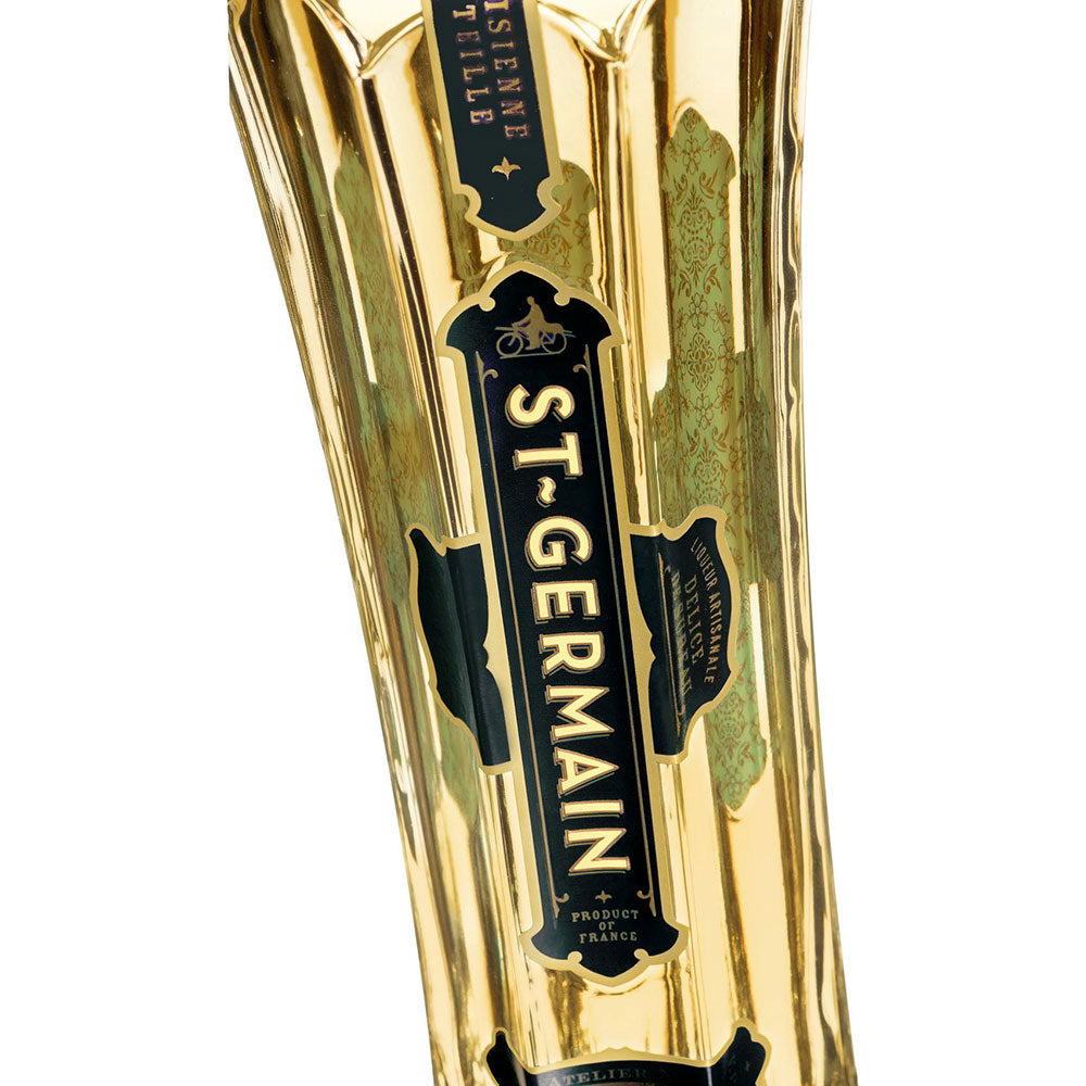 Nahaufnahme eines goldenen Flaschenetiketts im Art-Déco-Stil für den St. Germain Holunderblütenlikör 20% 0,7L, das diesen hochwertigen französischen Holunderblütenlikör der Marke St. Germain hervorhebt.