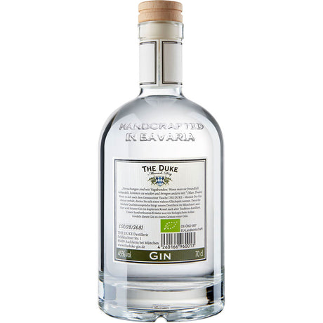Eine klare 0,7-Liter-Flasche The Duke Munich Dry Gin 45% von THE DUKE Destillerie, mit einem Holzdeckel und einem Etikett mit der Aufschrift "Handcrafted in Bavaria".