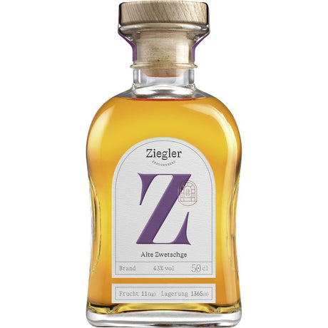 Eine 0,5-Liter-Flasche Ziegler Alte Zwetschge Brand 43% mit einem Holzdeckel und einem großen lila Z auf dem Etikett.