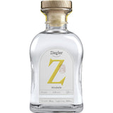 Eine Klarglasflasche Ziegler Mirabellenbrand 43% 0,5 Liter mit einem Holzdeckel und einem weißen Etikett mit einem markanten gelben Z.