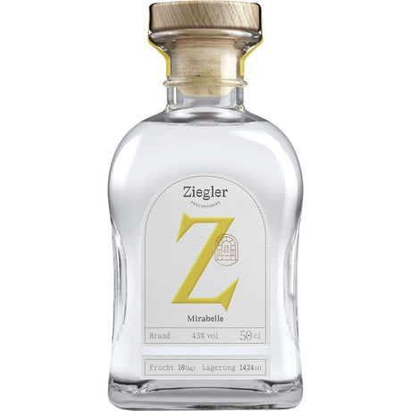 Eine Klarglasflasche Ziegler Mirabellenbrand 43% 0,5 Liter mit einem Holzdeckel und einem weißen Etikett mit einem markanten gelben Z.