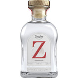 Eine Klarglasflasche Ziegler Sauerkirsch Brand 43% (0,5 l) mit einem Holzdeckel und einem großen roten Z auf dem Etikett.